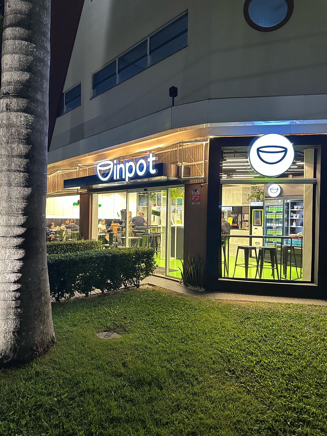 Fachada iluminada de loja Inpot à noite